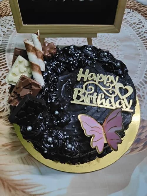Custom millet chocolate cake with handcrafted chocolate shards and a butterfly topper