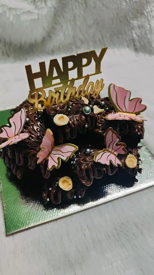 Chocolate brownie cake stack with pink butterfly decorations
